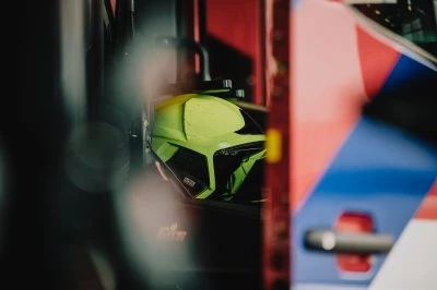 Een gedeeltelijk zichtbare brandweerhelm en blusvoertuig